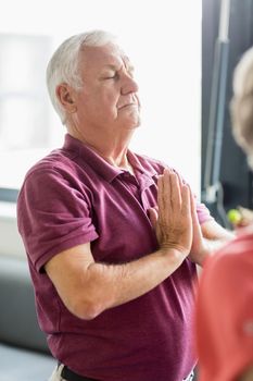 Seniors doing yoga with closed eyes in a retirement home