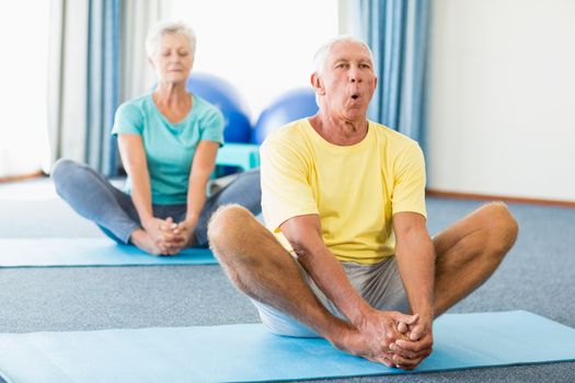 Seniors performing yoga in a studio