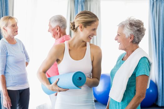 Instructor standing together with seniors during sports class