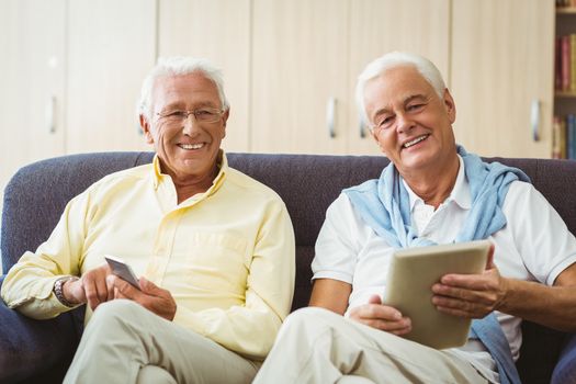 Senior men using technology in a retirement home