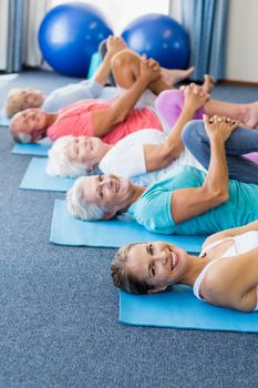 Instructor performing yoga with seniors during sports class