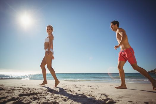 Young couple running on beach in summer