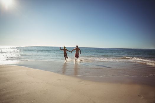 Couple running on beach in summer