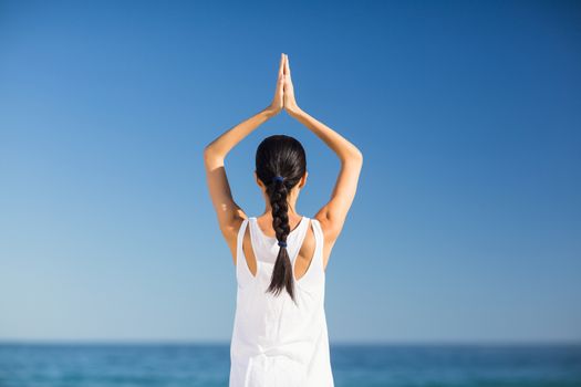 Young woman performing yoga on the beach