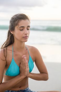 Young woman performing yoga on the beach