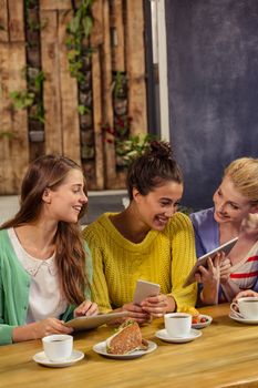 Friends using technology in a cafe