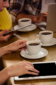 Friends using technology in a cafe