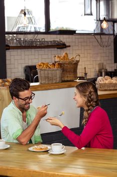 Smiling couple eating cake in the restaurant