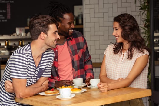 Friends talking together and smiling in cafeteria