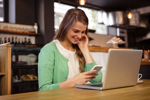 Smiling woman using technology in the cafe