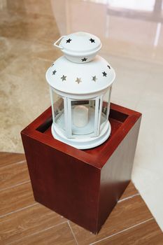 white metal candlestick in the lobby on a wooden stand