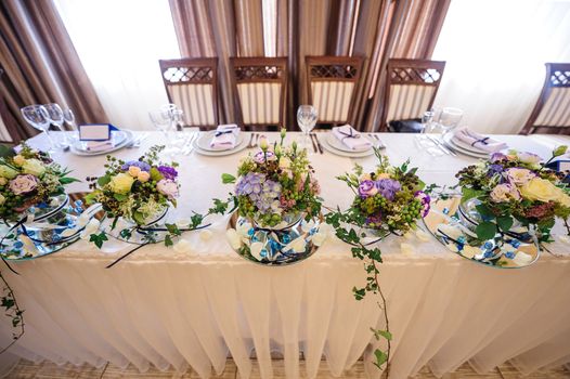 decor of flowers on wedding table bride and groom.