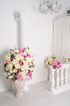 beautiful decoration of flowers in vases in white studio.