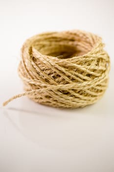 Ball of twine unrravels on white background