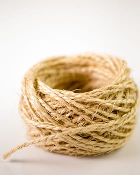 Ball of twine unrravels on white background