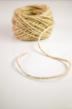 Ball of twine unrravels on white background