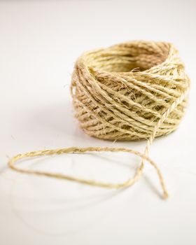 Ball of twine unrravels on white background