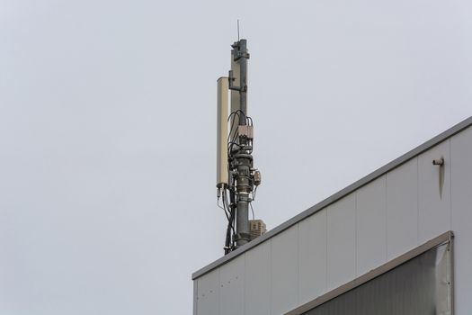 Antenna, telecommunications tower on a roof, wireless telecommunications concept.