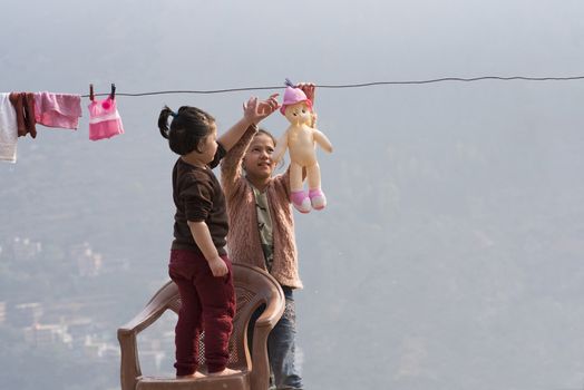 Kids wash their dolls and hang them out to dry on the clothesline. Children doing laundry and playing outdoors.