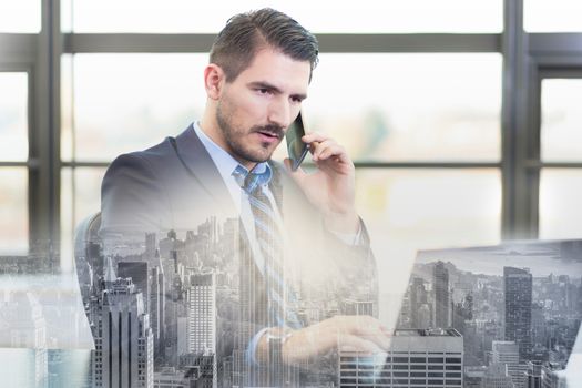 Portrait of successful corporate businessman in bright modern office focused on data on his laptop computer while talking on mobile phone. Business and entrepreneurship concept.