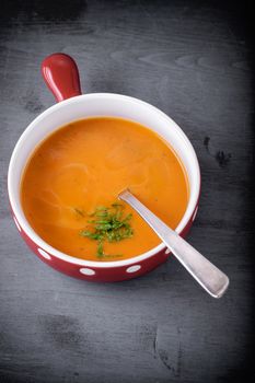 Pumpkin creme soup with a spoon served on a table