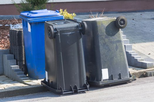 Dustbin with different colored lids for waste separation are upside down.

