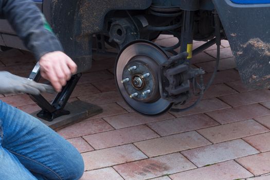 Disk brake on a car here Mechanic at the car brake repair in a car service workshop
