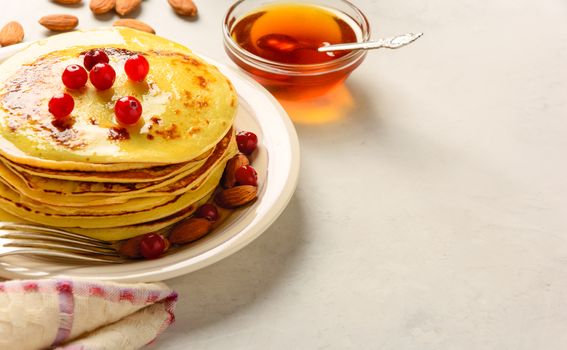 Pancakes with honey and almond on a white background. Copy space. 