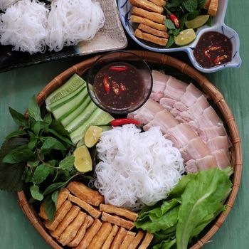 Delicious Vietnamese food, bun dau mam tom, is popular street food make from vermicelli with boiled meat, fried tofu, shrimp paste and green vegetables, cucumer and spice as chilli, lemon 