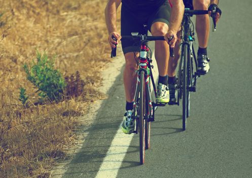 Cyclists riding a bicycle on the road.