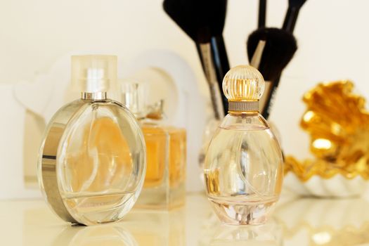 dressing table with women's accessories. perfume, jewelry and makeup brushes on a  table, close-up