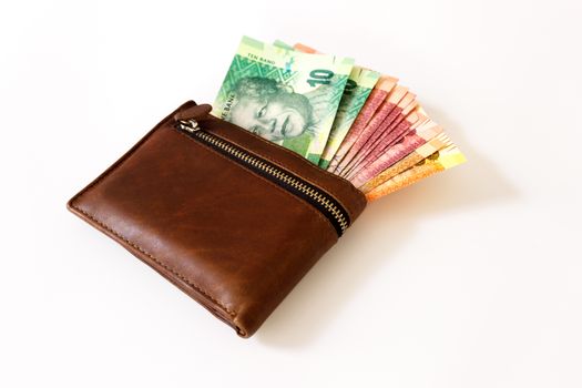 South African Rand in wallet sticking outoff a wallet on a white canvas