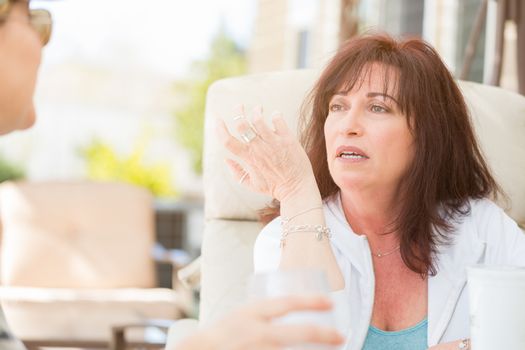 Two Female Friends Enjoying Conversation on the Patio.