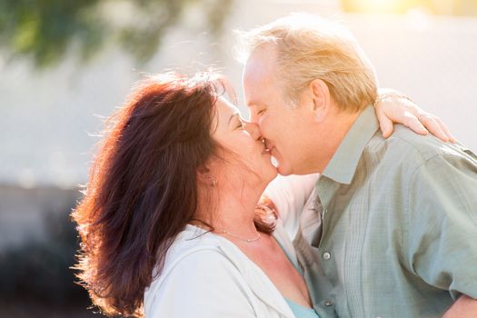 Happy Middle Aged Couple Enjoy A Romantic Slow Dance And Kiss Outside.