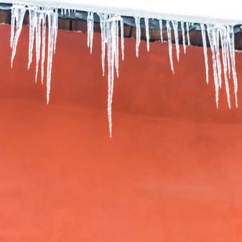 Icicles on the red house, abstrakt background