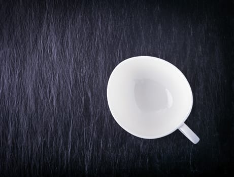 Empty of white porcelain cup  on a stone plate