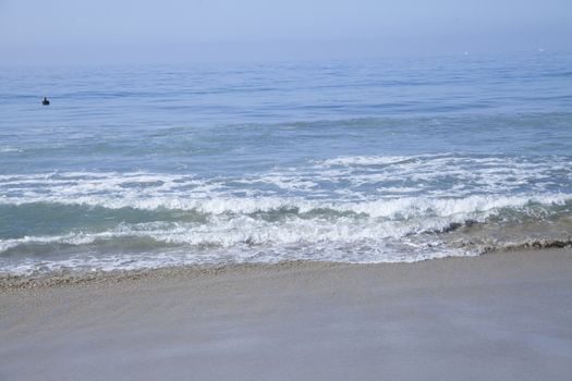 Heavy, foamy waves lapping at the ocean shore