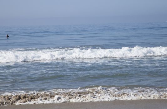 Heavy, foamy waves lapping at the ocean shore