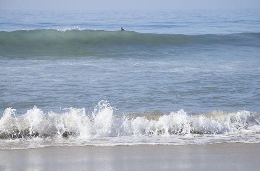 Heavy, foamy waves lapping at the ocean shore