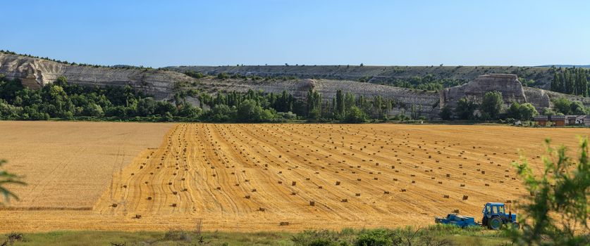 Field with bales of straw on a background of mountain scenery