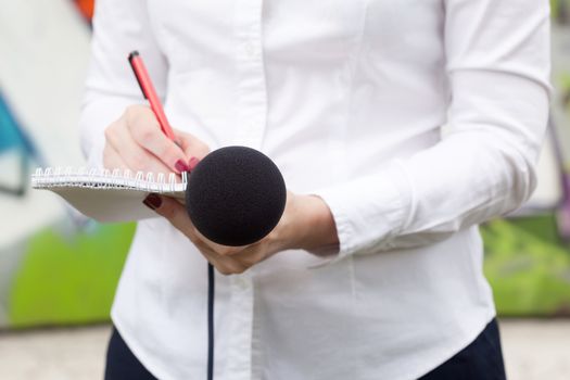 Female reporter taking notes at news conference