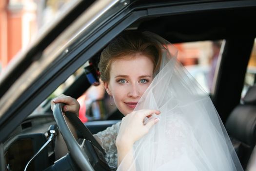 Portrait of a beautiful bride in a car