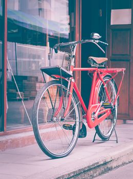 Vintage red bicycle standing on street in Thailand,