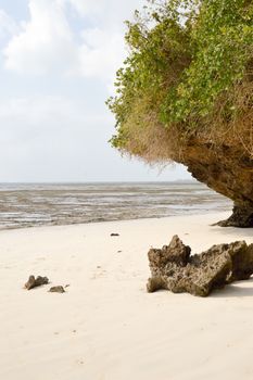 Small cove with a rock on the white sand of the bamburi beach in Mombasa, Kenya