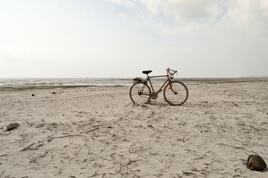 Red and white racing bike on the white sand of bamburi beach in Mombasa, Kenya