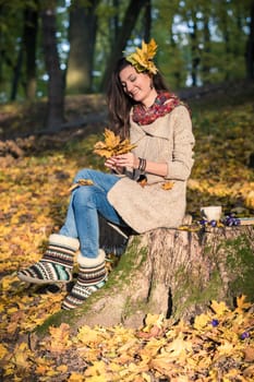 girl in autumn Park with leaves in the hands