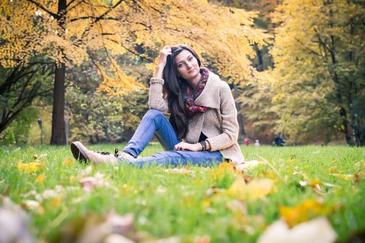 girl sitting on the grass in the autumn Park