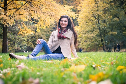 girl sitting on the grass in the autumn Park