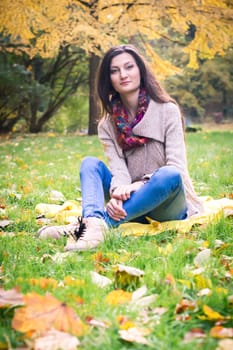 girl sitting on the grass in the autumn Park