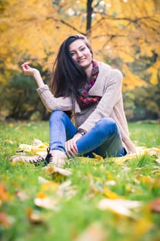 girl sitting on the grass in the autumn Park